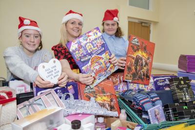Service manager Laura Wood and young people Chloe Sheldon and Bethany Cureton with some of the hundreds of gifts and advent calendars which have been donated for care leavers and their children