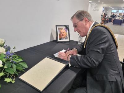 Mayor of Wolverhampton Councillor Dr Michael Hardacre signs the book of condolence to remember Councillor Ian Brookfield