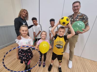 Hayley Miller, Project Manager at Ready, Set, Acti-Fit, Councillor Chris Burden, Cabinet Member for Children, Young People and Education, with young people enjoying some of the Yo! Wolves summer activities at Low Hill Community Centre