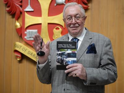 Councillor Phil Page, chair of City of Wolverhampton Council’s statutory licensing committee and regulatory committee, with a personal safety alarm and copy of the taxi drivers’ safety guide