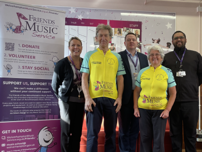 Ted and Denise Pearson are congratulated by Ciaran O'Donnell, Head of Wolverhampton Music Service (centre) and colleagues after completing their epic fundraising bike ride from John O’Groats to Land’s End