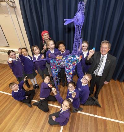 Councillor Dr Michael Hardacre, the City of Wolverhampton Council's Cabinet Member for Education and Skills, right, joined Hollie Jackson, Social Action Co-ordinator at St Anthony’s Catholic Primary School, and her group of Eco Warriors who have been busy filling the iron giraffe with recyclable bottle tops