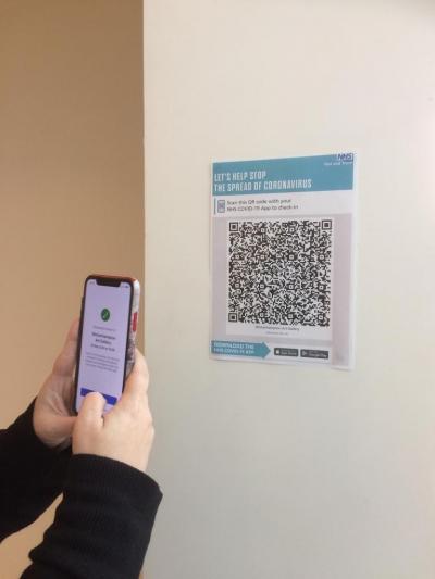 A visitor checks in to Wolverhampton Art Gallery by scanning the NHS Covid-19 app poster