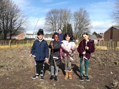 Merridale Primary School Year 3 pupils (from left) Aryan, Kayla, Navnoor and Niyah take part in the planting of the Tiny Forest with Councillor John Reynolds, Cabinet Member for Children and Young People and Chair of Governors at Merridale Primary School