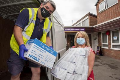 Councillor Linda Leach, Cabinet Member for Adults, helps stores driver Gary Parkes unload vital items of PPE at Bradley Reablement Centre