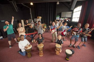 Councillor Dr Michael Hardacre, the City of Wolverhampton Council's Cabinet Member for Education and Skills, centre, joins young musicians at the Rock School, part of the Yo! Summer Festival