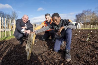 Investigating the mini beast tile at the Tiny Forest planting in Haggar Street, Blakenhall, are (from left) Councillor Steve Evans, cabinet member for city environment and climate change at City of Wolverhampton Council, Mitch Cross, Performance Manager, Severn Trent and Moses Bizimana from St Luke’s Primary School