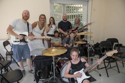 Councillor Beverley Momenabadi, Cabinet Member for Children and Young People, joins tutors Elliot (guitar), Peter (bass), Jemima (vocals) with young people taking part in the Yo! Summer Rock School holiday activity held by WV10 Consortium