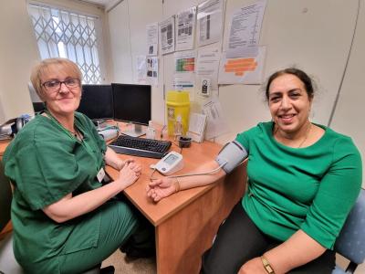 Councillor Jasbir Jaspal, Cabinet Member for Public Health and Wellbeing, gets her blood pressure checked by Jayne Norton, Nursing Associate at Bushbury Medical Centre
