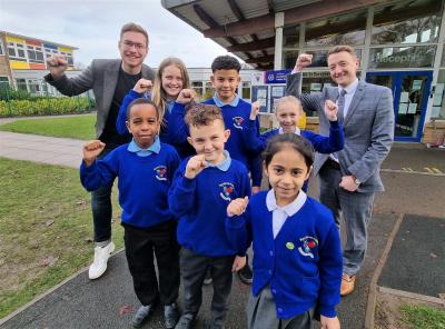 Councillor Chris Burden, Cabinet Member for Education, Skills and Work, back left, and Alistair Smith, Head of School, back right celebrate Berrybrook Primary School’s Good Ofsted rating with pupils