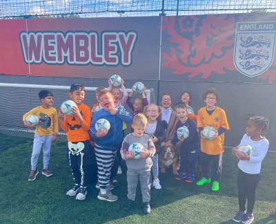 Councillor Beverley Momenabadi, the City of Wolverhampton Council's Cabinet Member for Children and Young People (back row), joins a football session with Kixx at Goals Black Country