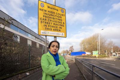 Councillor Jasbir Jaspal, the City of Wolverhampton Council’s Cabinet Member for Public Health and Wellbeing, with signage informing motorists of the High Court injunction in Bilston
