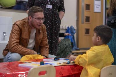 Councillor Chris Burden, the City of Wolverhampton Council's Cabinet Member for Children, Young People and Education, joins a young visitor for a stay and play session