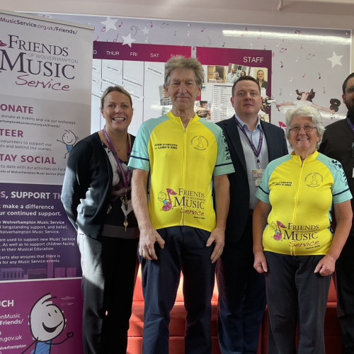 Ted and Denise Pearson are congratulated by Ciaran O'Donnell, Head of Wolverhampton Music Service (centre) and colleagues after completing their epic fundraising bike ride from John O’Groats to Land’s End